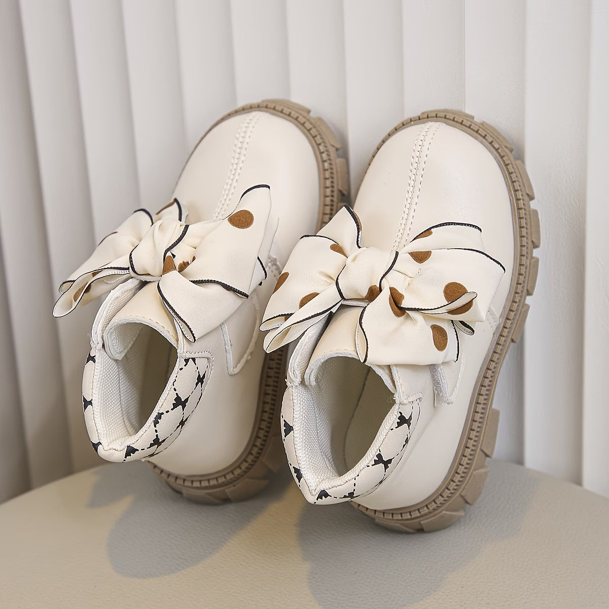 White shoes with decorative bows on a neutral background