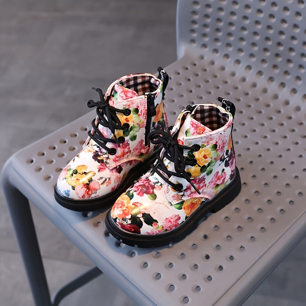 Floral patterned boots with black laces on a perforated chair.