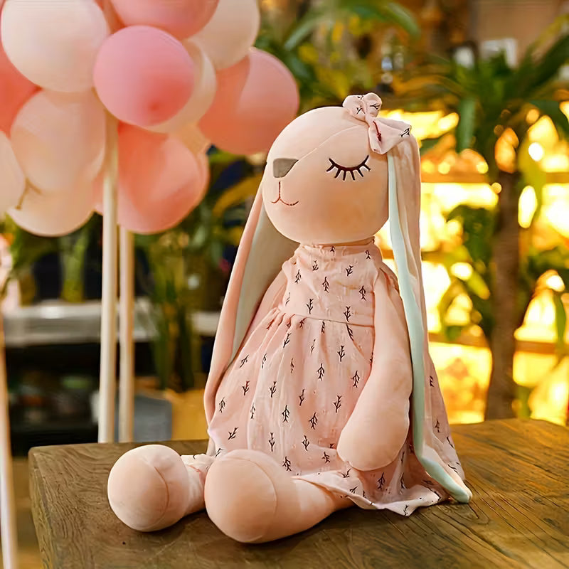Plush rabbit toy in a dress with pink and white balloons in the background